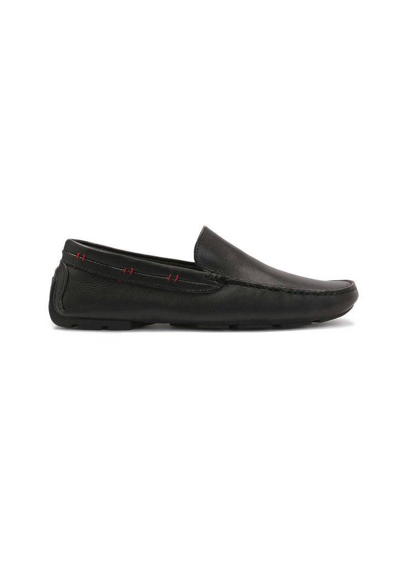 Scarpe slip-on in pelle nera con una finitura liscia, punta arrotondata e cuciture rosse a contrasto lungo il lato. Suola in gomma flessibile.