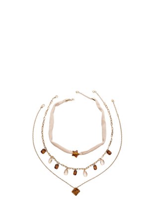 Tre lager guld-tonade halsband med bruna och klara stenar, inklusive en tygchoker med en stjärnformad sten.