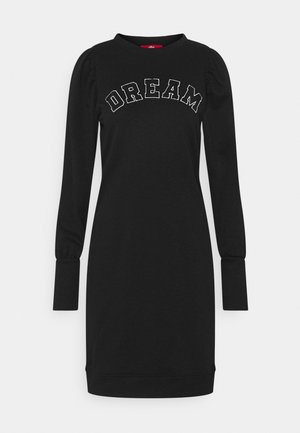 Vestido negro de manga larga con hombros abullonados y la palabra "DREAM" impresa en grandes letras blancas con contorno en el pecho.