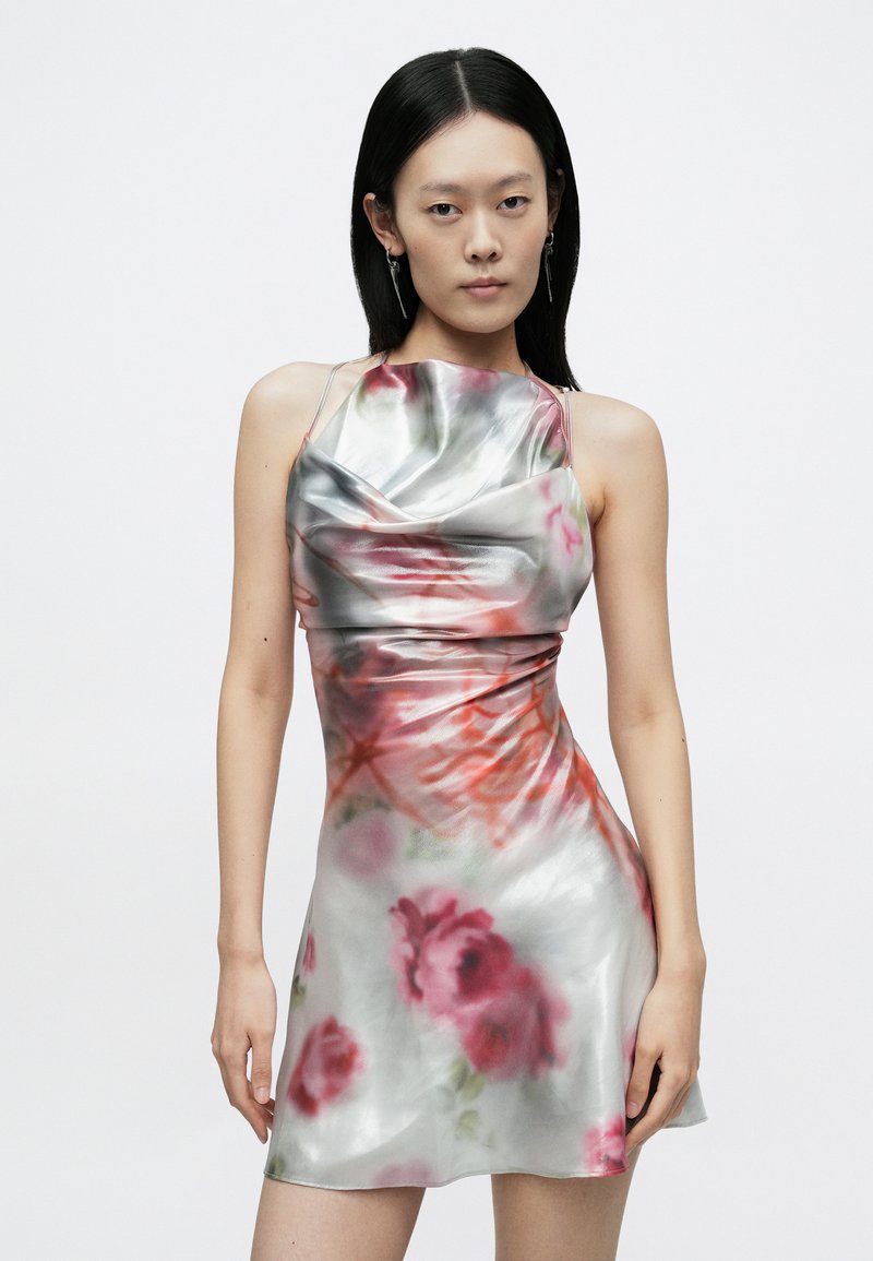 Satin mini dress with floral patterns in shades of pink and red, featuring a draped neckline and spaghetti straps. Smooth, reflective texture.