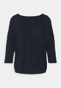 Mörkblå, avslappnad tröja med trekvartslånga ärmar och en vid halsringning. Mjuk textur med sidokilar och intrikata detaljer på axlarna.