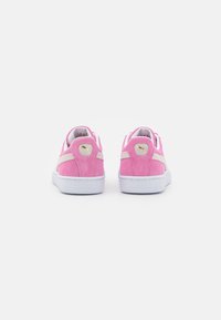 Rosa Wildlederschuhe mit weißen Gummisohlen und cremefarbenen Seitenelementen. Verfügt über ein goldenes Logo und weiche Texturen.