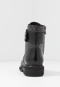 Černé kotníkové boty s vzorovaným textilním svrškem, hladkými koženými detaily, bočním zipem a ozdobným knoflíkem na kotníkovém pásku.