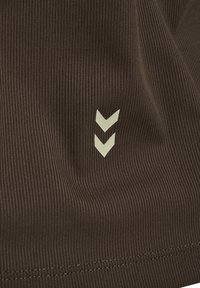 Brunt ribbat tyg har en texturerad yta med två ljusgrå nedåtriktade chevrons och en enkel stickad fåll.