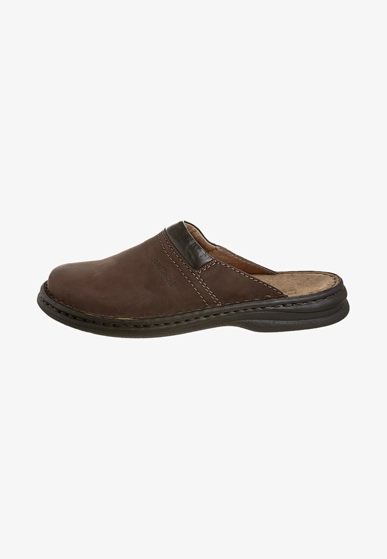 Zapato de cuero marrón tipo slip-on con un perfil bajo, forma curvada, acento de cuero oscuro contrastante y costuras visibles a lo largo de los bordes.