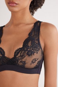Svart spets-bra med blommönster, med djup V-ringning, ribbad undervidd och mjuk, genomskinlig textur. Justerbara axelband ingår.