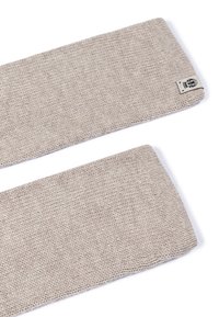 Beige knitted wool headband with a small fabric brand tag featuring a crown logo, displayed on a white background.