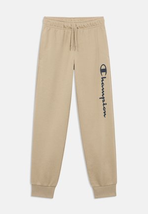 Beiget pehmeästä kankaasta valmistetut collegehousut, joissa on joustava vyötärönauha, resorit lahkeensuissa ja tumma logo vasemmassa lahkeessa.