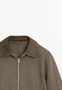 Brown jacket with a zip closure, featuring a suede collar and soft fabric texture. Design includes a simple, straight-cut silhouette.