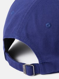 Gorra de béisbol azul marino con tela texturizada, correa metálica ajustable en la parte posterior y ojales cosidos para ventilación.