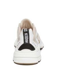 Zapatilla blanca con un upper de malla texturizada, acentos en beige, tapa de talón negra y una lengüeta negra y blanca a rayas en la parte posterior.