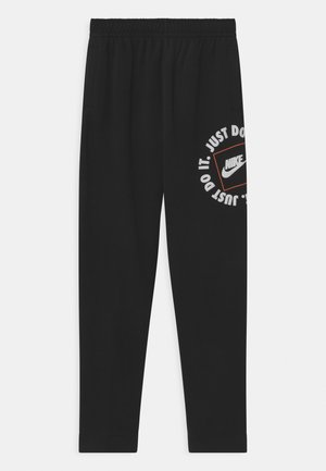Pantalones de chándal negros de Nike con cinturilla elástica, bolsillos laterales y logo impreso en blanco y naranja "Just Do It" en la pierna izquierda.