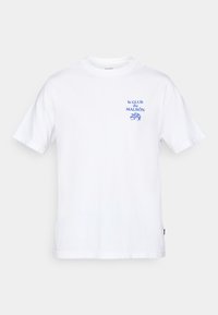 Hvid t-shirt med korte ærmer og blå tekst "le CLUB du MALBÔN" samt en lille blå grafik af citroner på venstre bryst.