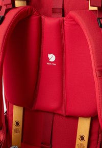 Κόκκινο σακίδιο πλάτης με επενδεδυμένη υποστήριξη πλάτης. Διαθέτει ξύλινη υποστήριξη και λουριά, εκ�τύπωση λογότυπου και ανθεκτικές ραφές για διάρκεια.