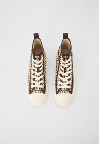 Hoge sneakers met een beige canvas bovenkant met bruine geometrische patronen. Crème veters en rubberen zolen, met treklussen op de hielen.