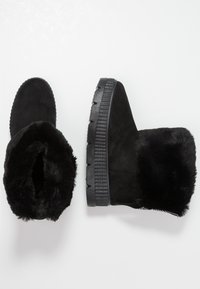 Svarta anklarstövlar i mocka med faux fur-foder. Chunky gummisulor med texturerat mönster och zigzagdetaljer.