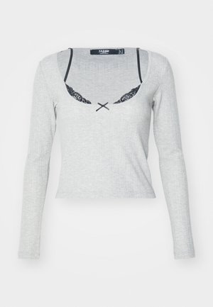 Gray ribbed long-sleeve top with a scoop neckline, featuring black lace trim and a contrasting black bow detail at the center front.