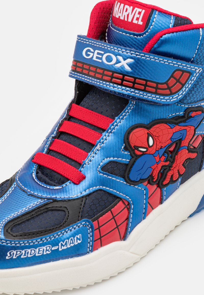 Zapatillas altas con un acabado sintético azul y detalles rojos, un gráfico de Spider-Man, detalles de malla y una correa de Velcro.