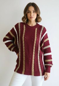 Burgundowy sweter dziany z pionowymi paskami w kolorach złotym, białym i brązowym; posiada szerokie rękawy i prążkowany okrągły dekolt.