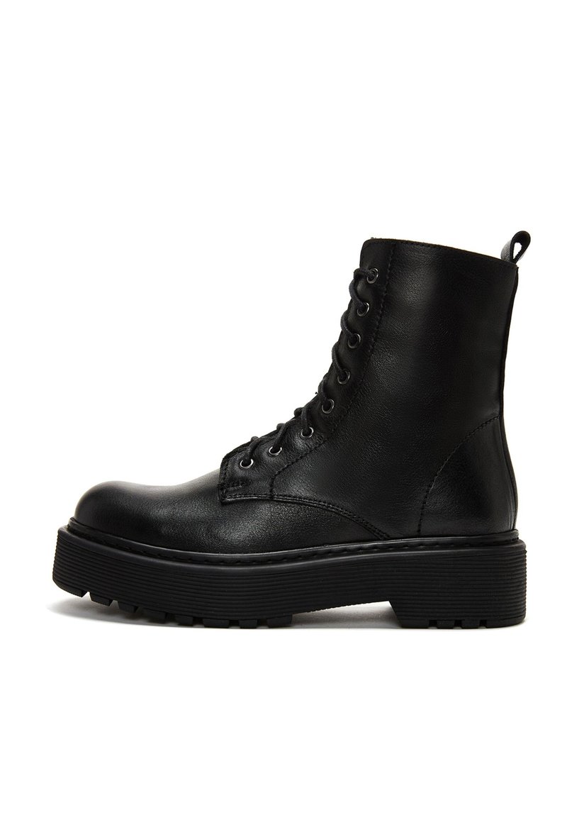 Stivaletto in pelle nera con superficie texturizzata, punta rotonda, occhielli in metallo e suola in gomma spessa. Presenta un tassello sul retro.