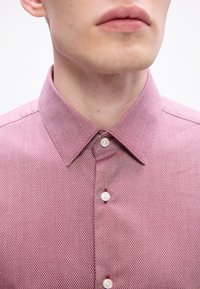 Camicia a maniche lunghe rossa con motivo a trama, colletto strutturato e dettagli dei bottoni bianchi, realizzata in tessuto testurizzato per una maggiore profondità.