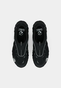 Ζευγάρι μαύρα παπούτσια νερού North Face με κλειστή μύτη, διχτυωτές επιφάνειες και εκτύπωση "Flight Series" στο εσωτερικό, πάνω σε λευκό φόντο.