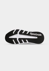 Μαύρη και άσπρη σόλα αθλητικού παπουτσιού Reebok με βαθιές αυλακώσεις και υφή για καλύτερο κράτημα, με το λογότυπο της Reebok κοντά στη φτέρνα.