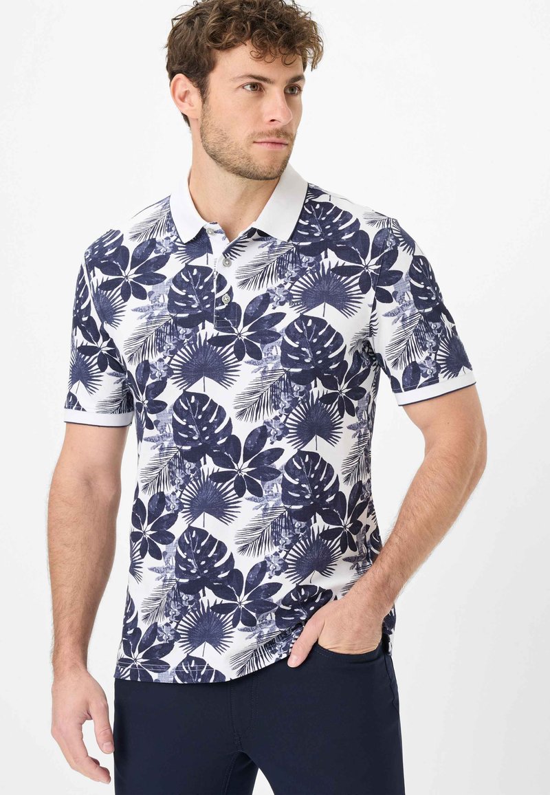 Polo à manches courtes avec un motif floral bleu marine et blanc, patte de boutonnage, et un col et des poignets de manches blancs contrastants.