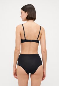 Svart undertøysett med en enkel, glatt bralette med justerbare stropper og høyt liv-truser, laget av myk, elastisk stoff.