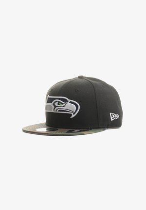 Black cap with a raised Seattle Seahawks logo on the front, camo-patterned visor, fitted style, with white accents on the logo and side.