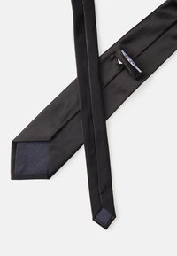Cravate à rayures noires avec une texture lisse et des accents bleu marine unis. Elle présente des extrémités pointues et un motif subtil sur le revers.