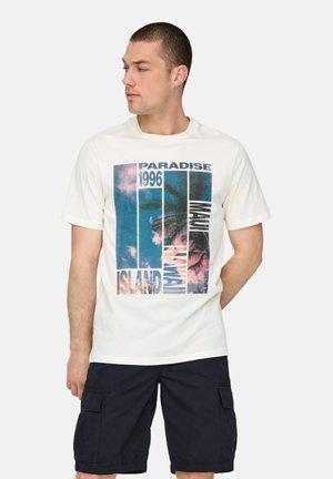 Camiseta blanca de algodón con un estampado gráfico de palmeras y el texto "PARADISE 1996 ISLAND MAUI", combinada con pantalones cortos cargo oscuros.