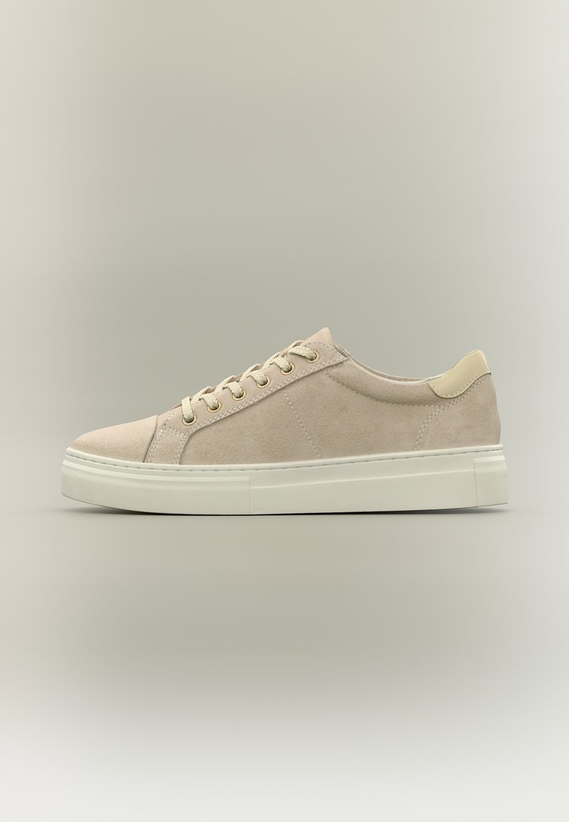 Baskets basses en daim beige avec semelle en caoutchouc crème et lacets assortis, vues de côté sur un fond neutre.