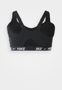 Melnā sporta krūšturis ar regulējamām siksnām, teksturētu audumu un elpojošu sietu. Iezīmēts ar baltu Nike logo uz siksnas.