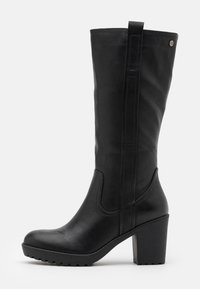 Botte noire montante en matériau synthétique lisse, avec un talon bloc rectangulaire, des accents subtils sur les côtés et une languette en haut pour un enfilage facile.