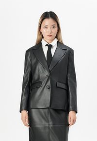 Sort læderblazer med en skræddersyet pasform, der har klippet revers, to forlommer og lukning med to knapper. Glat tekstur og struktureret design.