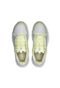 Chaussures de sport imperméables blanches et vert clair avec un mesh texturé et une semelle en caoutchouc, arborant des lacets jaunes réfléchissants et des accents de logo.