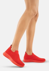 Rote Slip-On-Sneaker mit einem atmungsaktiven Mesh-Obermaterial und strukturierten Akzenten. Leichte Sohle in passender Farbe, abgerundete Zehenform.