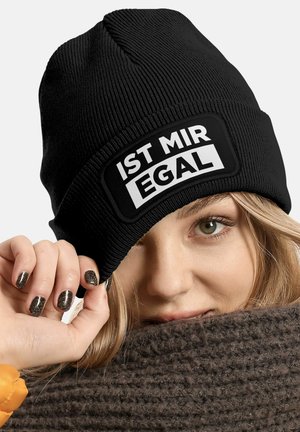 Black beanie featuring a textured knit design and a prominent white patch with the printed text "IST MIR EGAL." Upper edge emphasizes a snug fit.