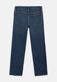 Σκούρο μπλε τζιν με ευθεία γραμμή στο πόδι. Διαθέτει δύο πίσω τσέπες και αντίθετη ραφή. Το ύφασμα έχει μια διακριτική υφή.