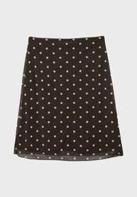 Černá áčková sukně s bílými puntíky, lehká tkanina a mírně průsvitná textura.