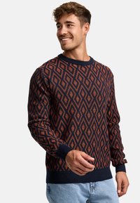 Pulover bleumarin cu un model texturat în formă de diamant de culoare portocalie. Guler rotund și manșete dublate, cu un fit confortabil. Stil casual.