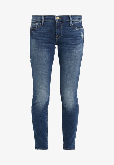 Jeans skinnies em denim azul escuro com áreas desbotadas e ligeira desgastação. Apresenta um design clássico de cinco bolsos e fecho frontal com botão.