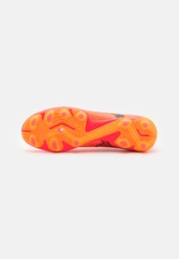 Voetbalschoen met een helderroze en oranje zool, gestileerd patroon, stevige rubberen grip en een zwarte mesh bovenkant voor flexibiliteit.
