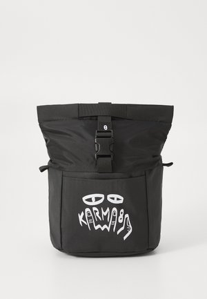 Black backpack with a fold-over top, featuring a clip closure. Front pocket displays white graphic text and abstract designs. Durable fabric texture.