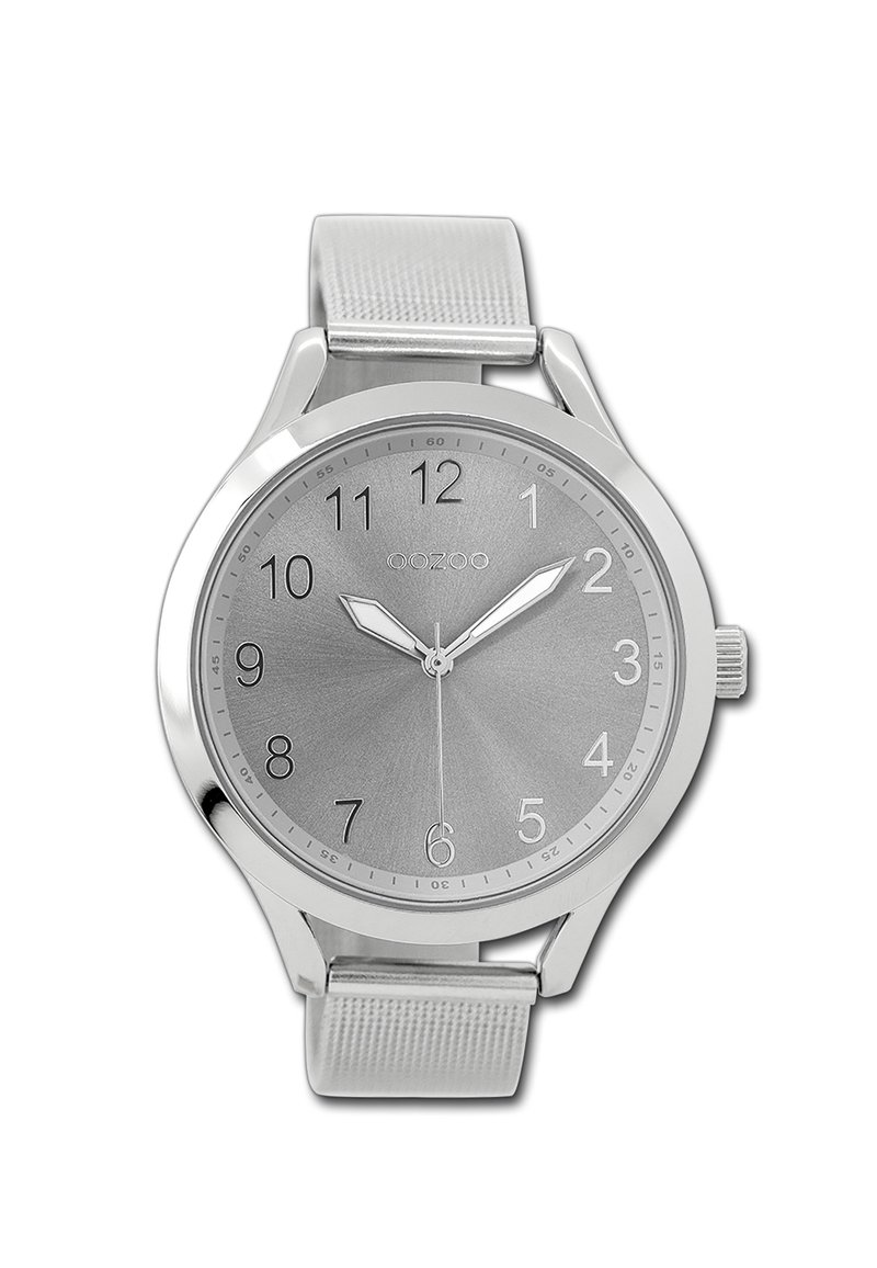 Montre argentée avec un bracelet métallique, cadran rond, fond gris, chiffres arabes et deux aiguilles argentées. Logo de la marque visible en haut.