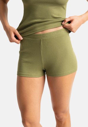Shorts en maille côtes vert olive avec une large taille élastique et un design ajusté, présentant une texture lisse et des détails de couture minimalistes.