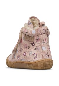 Růžová dětská botička s květinovým vzorem, měkkým podšívkováním, gumovou podešví a štítkem "Barefoot Naturino" na boku.