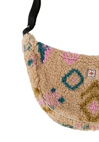 Béžová fleecová taška cez rameno s ružovými, modrými a žltými kvetinovými vzormi a čiernym nastaviteľným popruhom.