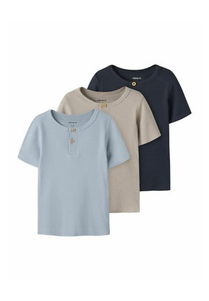 Tre ribstrikkede kortærmede småbørns T-shirts i blå, beige og navy, hver med to træknapper nær den runde halsudskæring.